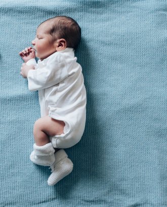 Newborn child sleeping on blue blanket