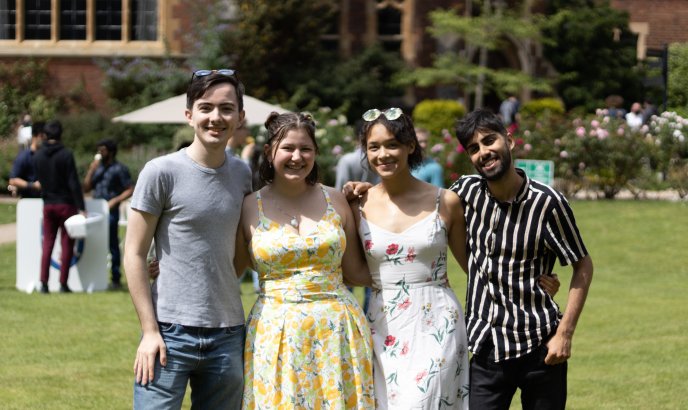 Four students posing at a garden party